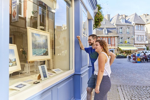 Un jeune couple découvre les vitrines du circuit des métiers d'art à Paimpol en Bretagne.